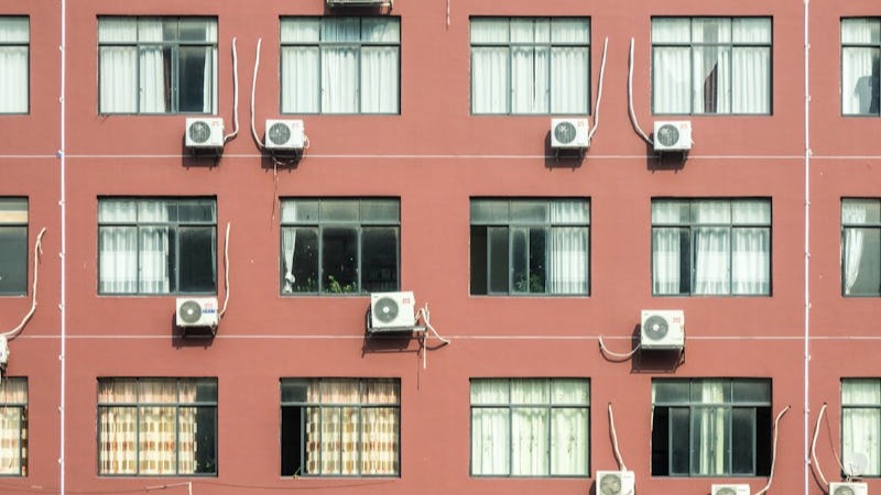 Technician servicing a window AC unit in Qatar